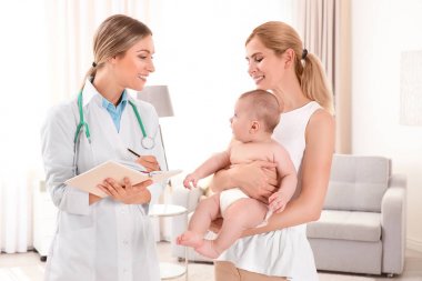 Doktor bir şey defter ve bebek evde annesiyle yazma