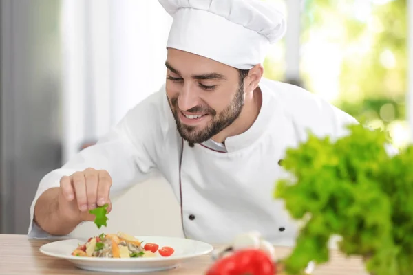 Joven chef masculino adornando su plato — Foto de Stock