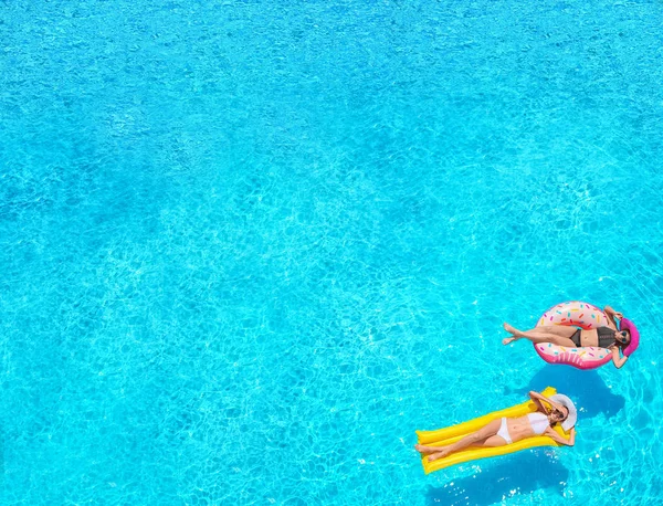 Belles jeunes femmes avec beignet gonflable et matelas dans la piscine — Photo