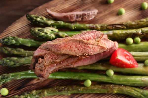 Sliced steak served with asparagus — Stock Photo, Image