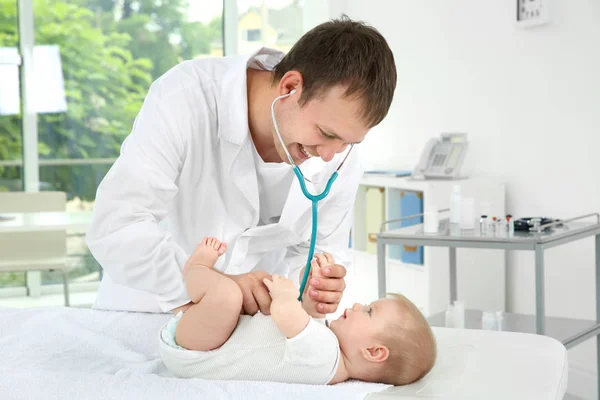 Врач осматривает симпатичного ребенка со стетоскопом в больнице — стоковое фото