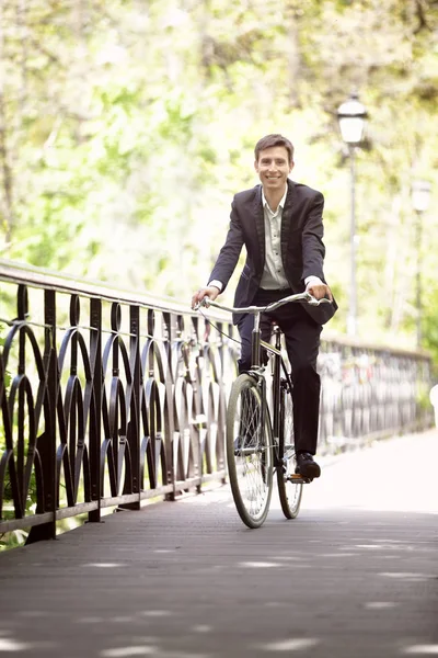 Genç yakışıklı işadamı güneşli günü açık havada bisiklet ile