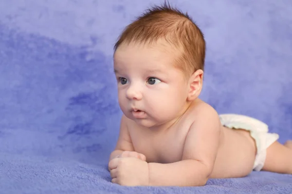 Lindo bebé acostado sobre cuadros suaves — Foto de Stock