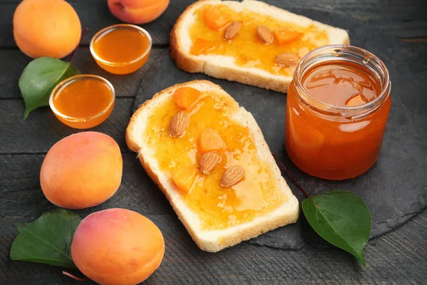 Slices of bread and jar with apricot jam — Stock Photo, Image