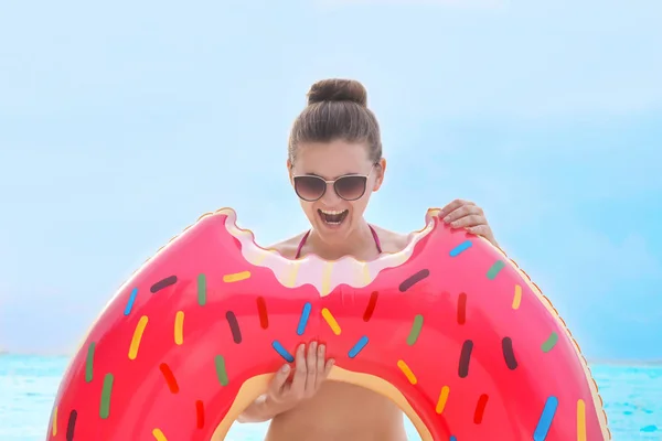 Mujer con donut inflable colorido — Foto de Stock