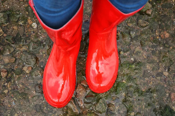 Vrouw in rode rubberen laarzen — Stockfoto