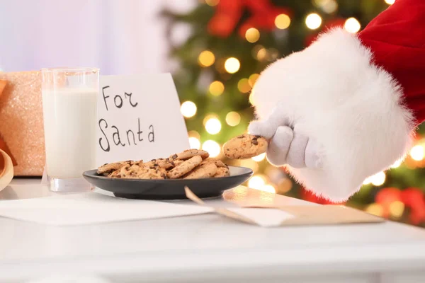 Papai Noel tomando biscoito da placa — Fotografia de Stock