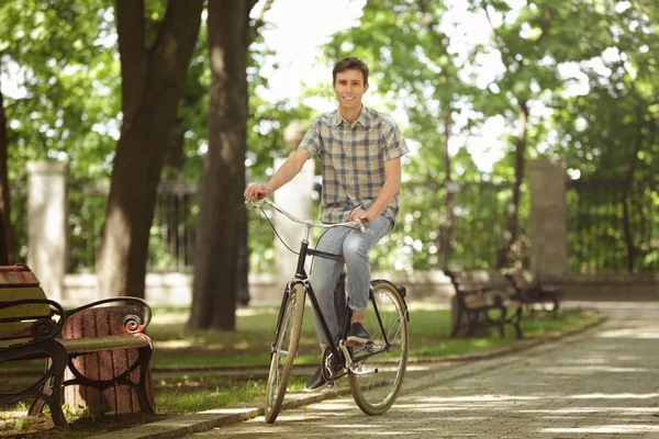 Ung vacker man med cykel utomhus på solig dag — Stockfoto