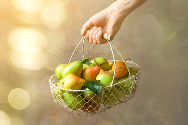 Woman holding basket with ripe pears \ — Stockfoto