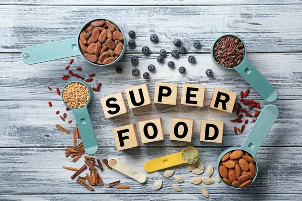 Küpleri ve kaşık ahşap arka plan üzerinde ölçüm superfood ürün yelpazesine kompozisyonu