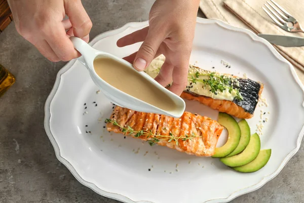 Kadın boşaltma balık sosu plaka üzerinde 