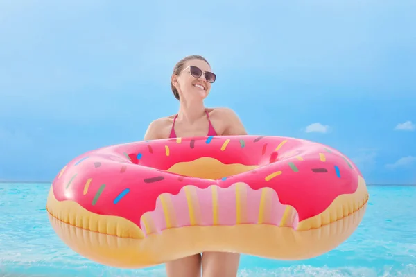 Mulher com donut inflável colorido — Fotografia de Stock