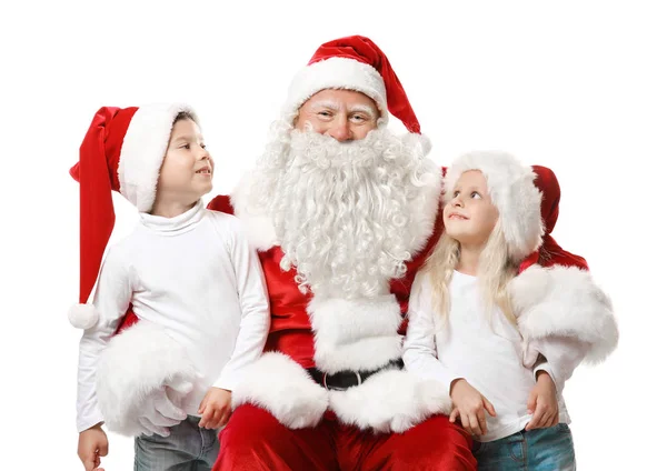 Carino i bambini in cappelli di Natale e autentico Babbo Natale su sfondo bianco — Foto Stock