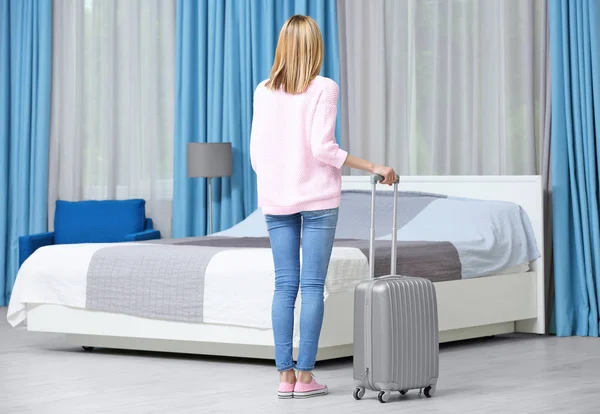 Junge Frau mit Gepäck im Hotelzimmer — Stockfoto