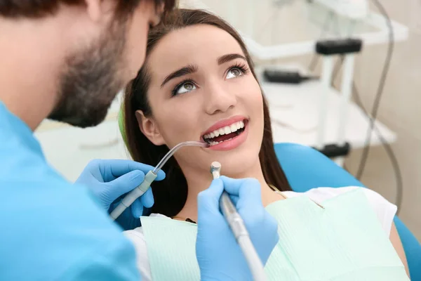 Dentista perfurando os dentes do paciente na clínica — Fotografia de Stock