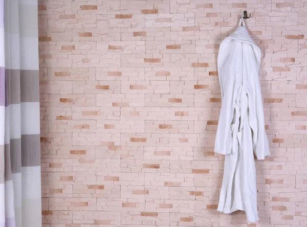 Badrock hängande på tegelvägg — Stockfoto