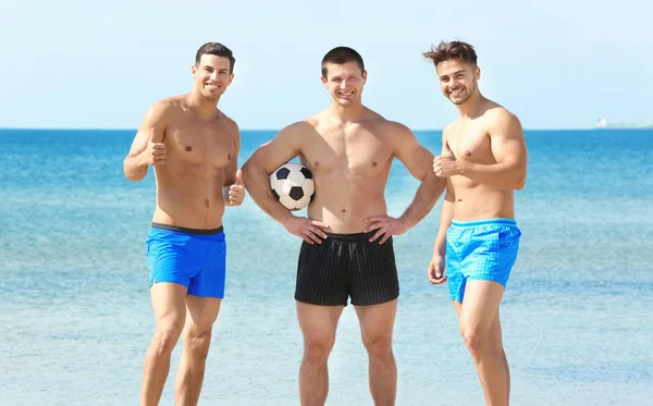 Deniz plaj futbol topu ile yakışıklı genç adam