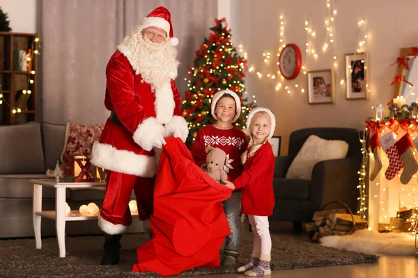 Babbo Natale presenta ai bambini carino in camera con belle decorazioni natalizie — Foto Stock