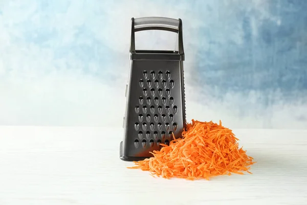 Metal grater and heap of carrot — Stock Photo, Image