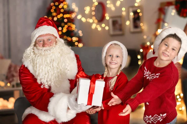 Weihnachtsmann beschenkt Kinder im Zimmer mit schöner Weihnachtsdekoration — Stockfoto
