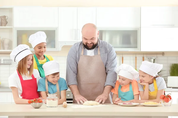 Группа детей и преподавателей на кухне во время уроков кулинарии — стоковое фото