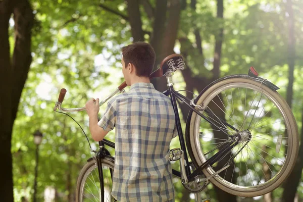 Jonge knappe man met fiets op het schouder, buitenshuis — Stockfoto