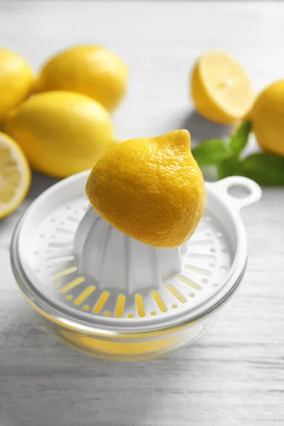 Composizione con limoni tagliati e spremiagrumi in plastica — Foto Stock