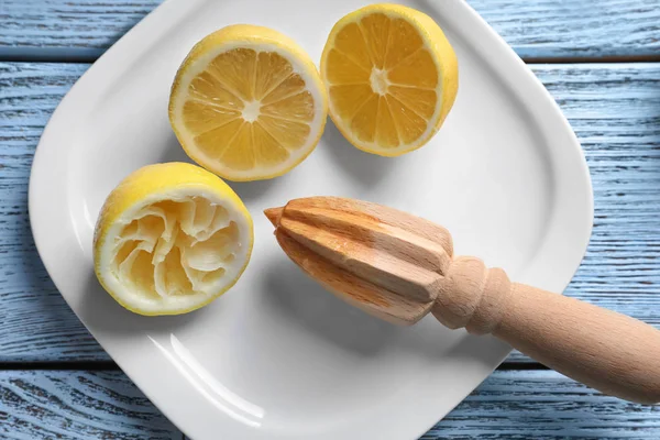 Limones cortados y escariador de madera cítrica —  Fotos de Stock