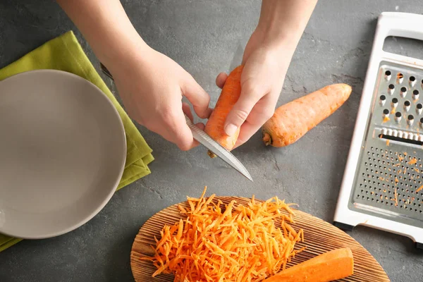 Woman peeling carrot — Stock Photo, Image