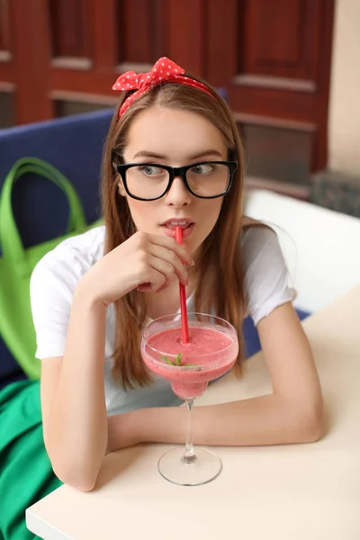 Jeune femme hipster boire smoothie rose à l'intérieur — Photo