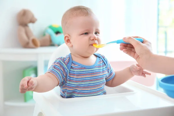 Mutter füttert Baby mit Löffel im Haus — Stockfoto