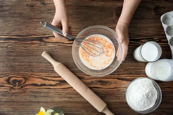 Elderly woman making dough in bowl — Stock Photo, Image