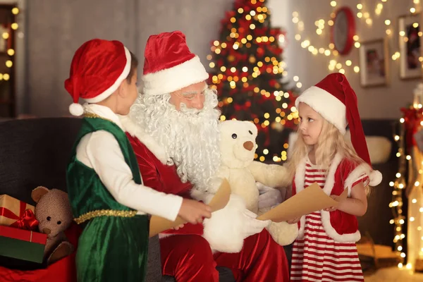 Carino elfo bambini che mostrano lettere a Babbo Natale in camera con bella decorazione di Natale — Foto Stock