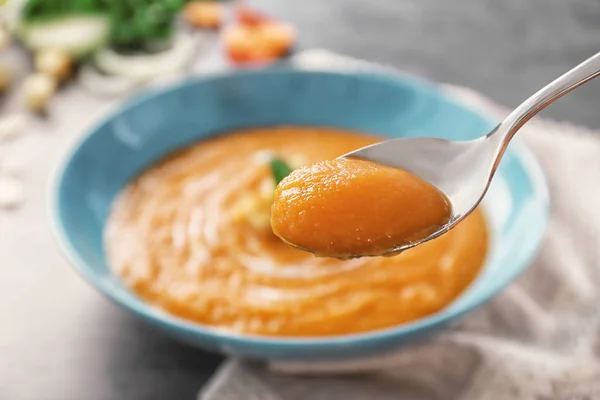 Cuillère avec une délicieuse soupe aux carottes — Photo