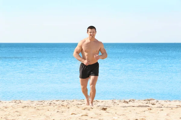 Deniz plaj üzerinde çalışan yakışıklı genç