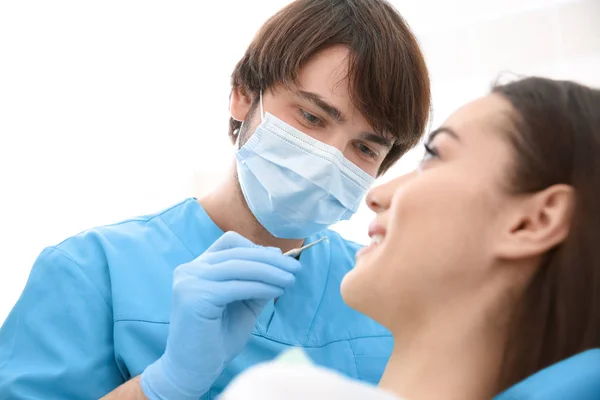 Дантист осматривает женские зубы в клинике — стоковое фото