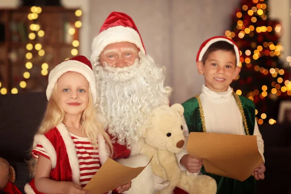 Söt elf barn med bokstäver och Jultomten i rum med vackra juldekoration — Stockfoto