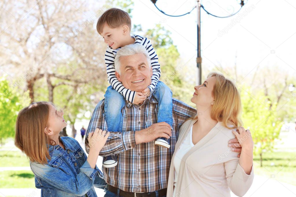 Cute happy children with grandparents in spring park
