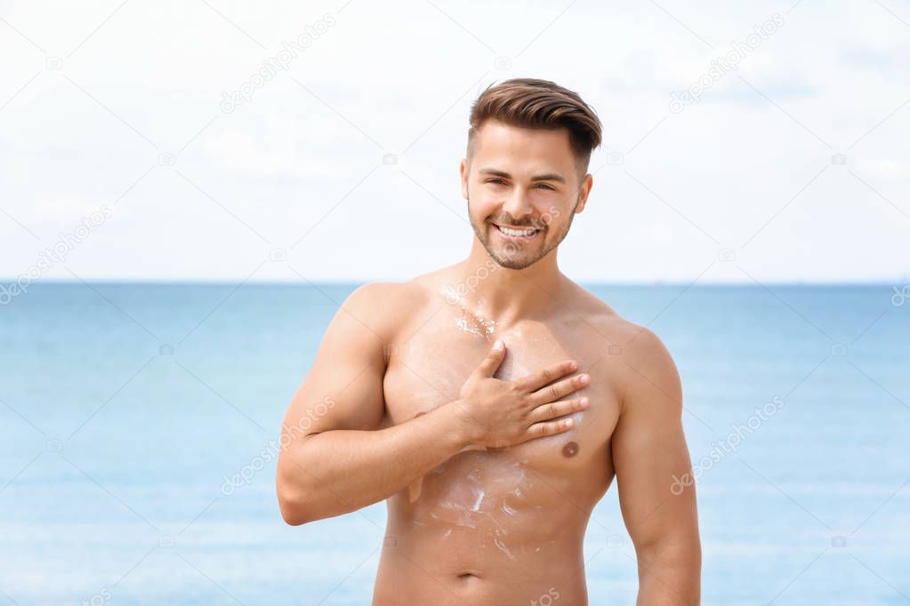 young man applying sunscreen cream 