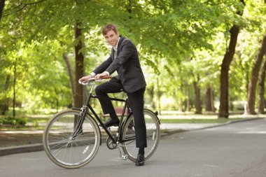 Genç yakışıklı işadamı güneşli günü açık havada bisiklet ile