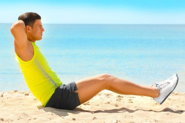 Deniz kumsalda eğitim yakışıklı genç