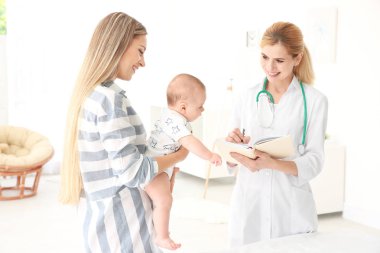 Doktor bir şey defter ve bebek evde annesiyle yazma