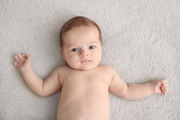 Lindo bebé acostado en cuadros suaves en casa — Foto de Stock