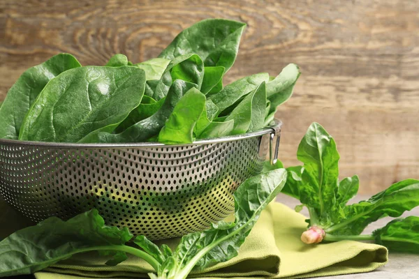 Colander with spinach leaves — Stock Photo, Image
