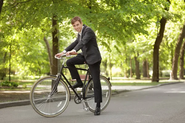 Genç yakışıklı işadamı güneşli günü açık havada bisiklet ile