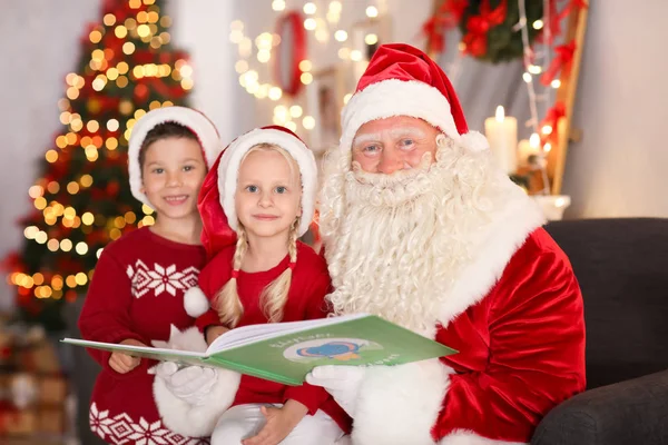 아름 다운 크리스마스 훈장을 가진 방에 있는 귀여운 아이 들에 게 본격적인 산타 읽기 책 — 스톡 사진