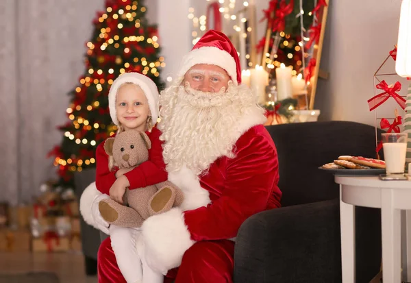 Jultomten och söt liten flicka med leksak i rummet inredning till jul — Stockfoto