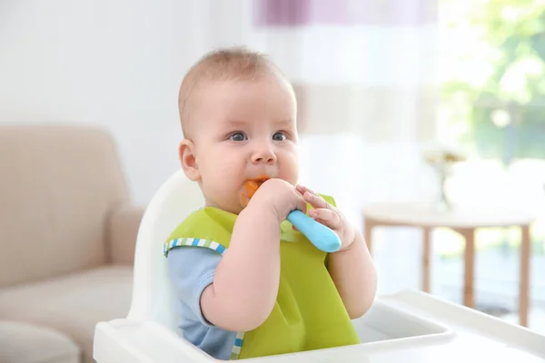 Lindo bebé con cuchara sentado en la cocina — Foto de Stock