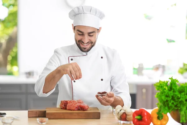 Young male chef cooking meat — Stock Photo, Image