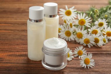 İki şişe ve chamomiles ile kozmetik kavanoz 